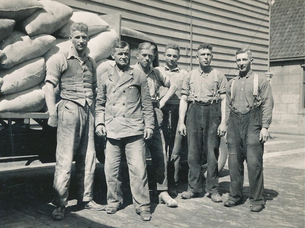 Jan Nat met zoon en personeel naast pakhuis De Hoop (circa 1950). Van links naar rechts Dirk Nat (1920), zijn vader Jan Nat (1894), Henk van Braam, Egbert Drent, Dirk Berkhout en Niek de Wolf.