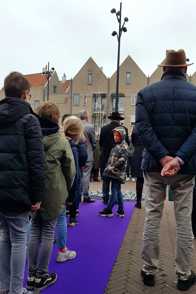 Kinderen wachten op hun beurt om een steen te leggen bij het monument op het Canadaplein.