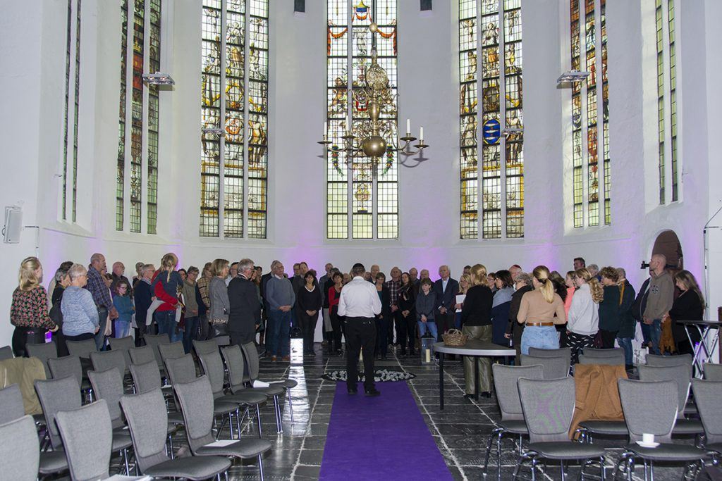 Levenslicht omringd door jong en oud tijdens het gebed in de Grote Kerk Schermerhorn. Foto: Marja Okx.