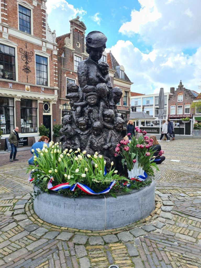 Het beeld van Truus Wijsmuller omringd door tulpen. De rood-witte is de Tante Truustulp.