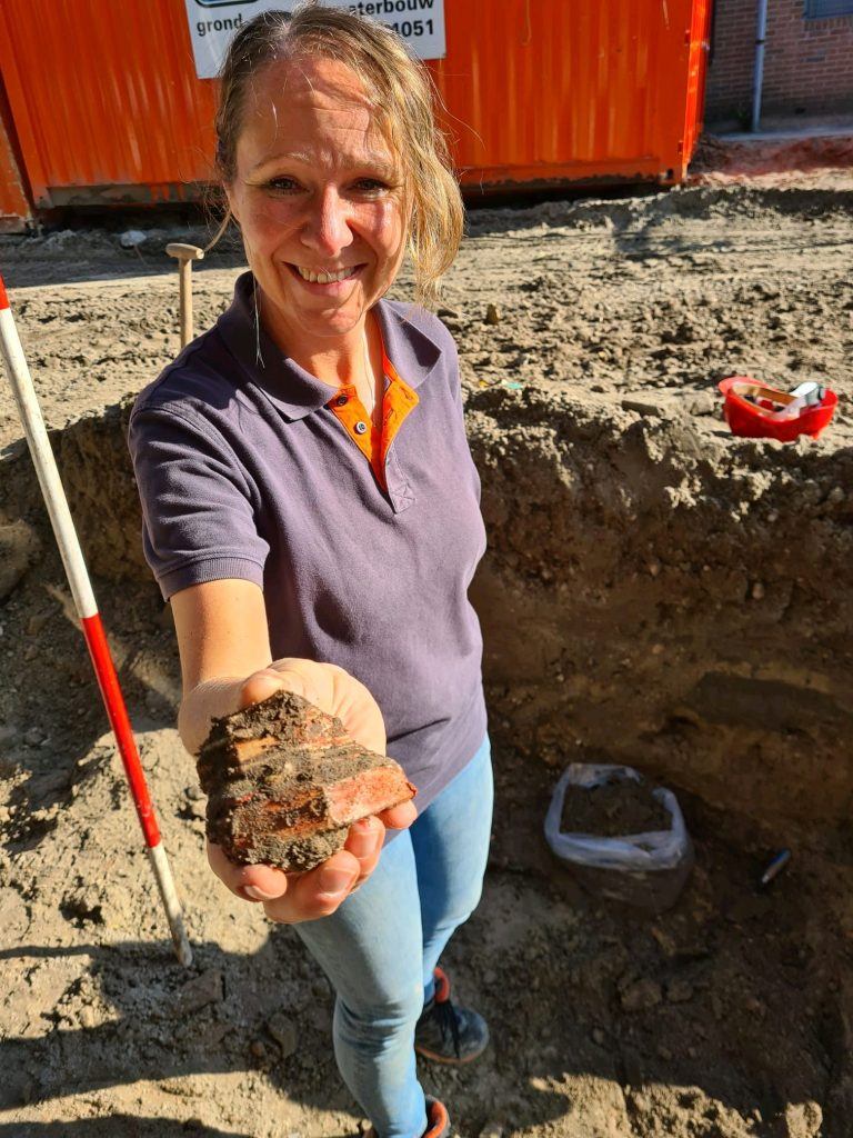 Nancy de Jong met een stuk van een sokkel van een heiligenbeeld