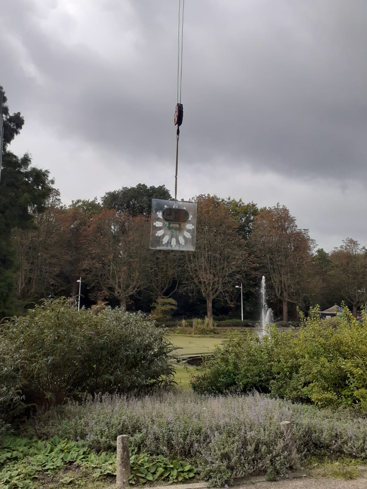 Glazen wijzerplaat in het groene decor bij Westerlicht