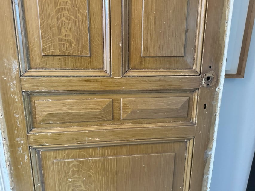 Deel van een deur die beschilderd is in eikgen houtpatroon