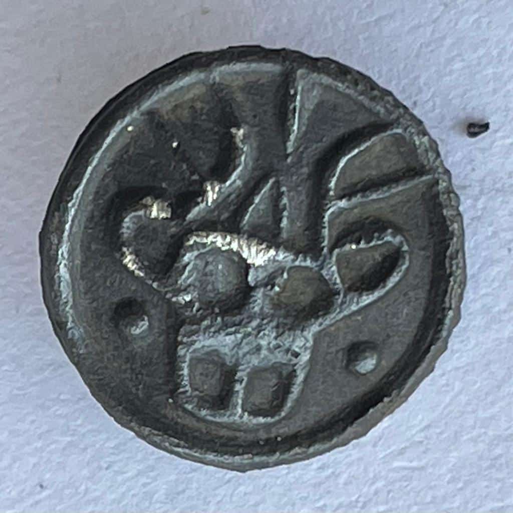 Een knoopvormig insigne met in reliëf de afbeelding van een hertenkop