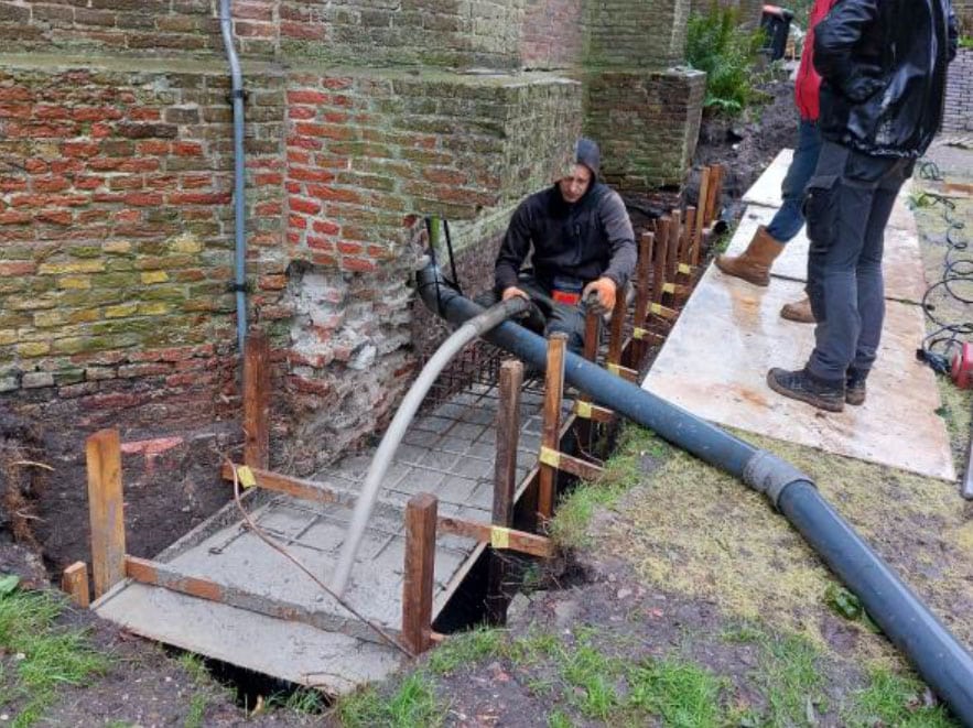 Storten van beton aan buitenzijde van de Dorpskerk Grootschermer