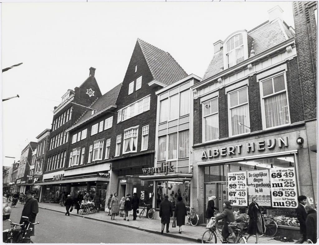 Op de plek van Langestraat 60 heeft ooit de Nederlandse dichteres en graveerster Maria Tesselschade Roemers Visscher (1594-1649) gewoond. Gevelwand. Rechts vooraan Langestraat 60. supermarkt Albert Heijn (AH). 
Gemeente Alkmaar / Collectie Regionaal Archief Alkmaar / RAA011004251.