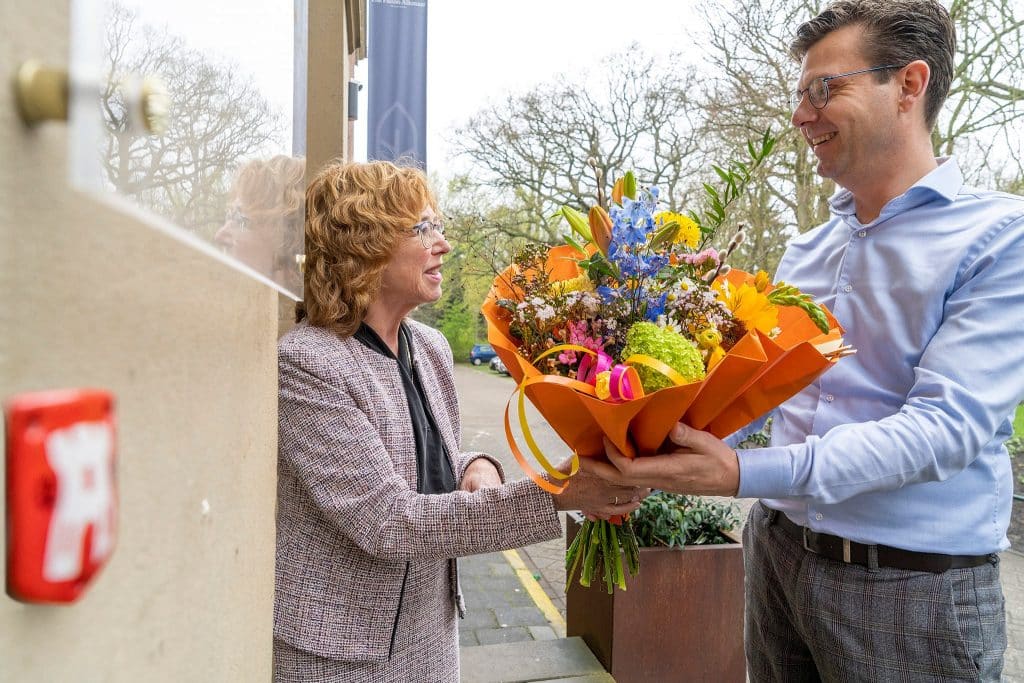 Anjo van de Ven overhandigt Jerry Breg bloemen