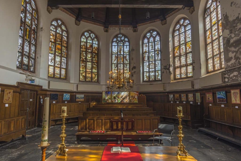 Interieur van de Grote Kerk De Rijp. Je ziet een aantal van de gebrandschilderde ramen. Deze zijn geschonken door verschillende omliggende steden na de grote brand in 1654. Foto Ritske Velstra