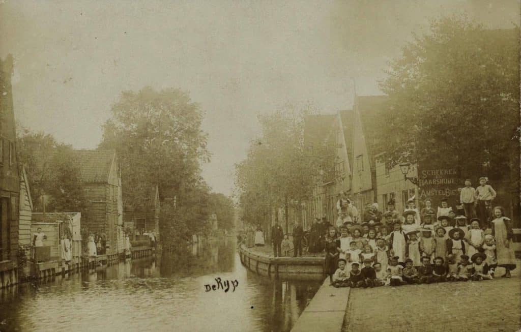 Prentbriefkaart van De Rijp. De Tuingracht bij de brug over het Bakkersgrachtje. De fotograaf stond naast de Grote kerk. Foto P. Jonker circa 1905 Collectie Kaptein.