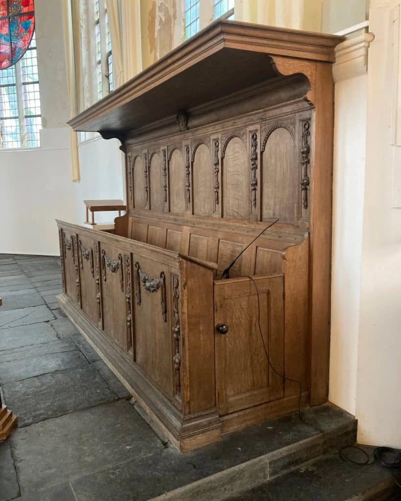 Rijkversierde kerkbanken in de protestantse kerk aan de Noordervaart in Stompetoren.