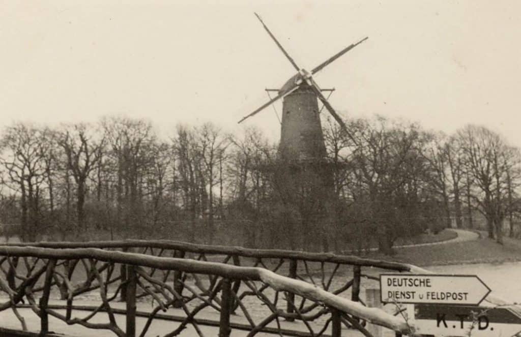De Kneppelbrug over de Kennemersingel in circa 1943. Op de brug een bord dat verwijst naar de Deutsche Dienst Feldpost. In de achtergrond de molen van Piet.