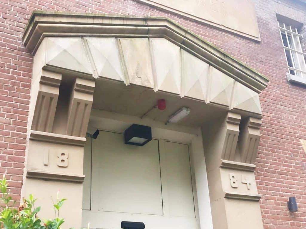 Omlijsting van de hoofdentree van de voormalige gevangenis Schutterswei. Zie de dubbele console met groeven. En het driehoekige fronton dat versierd is met enorme diamantkoppen.