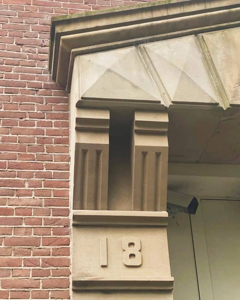Omlijsting van de hoofdentree van lichtbruine zandsteen uit de groeven bij Udelfangen.