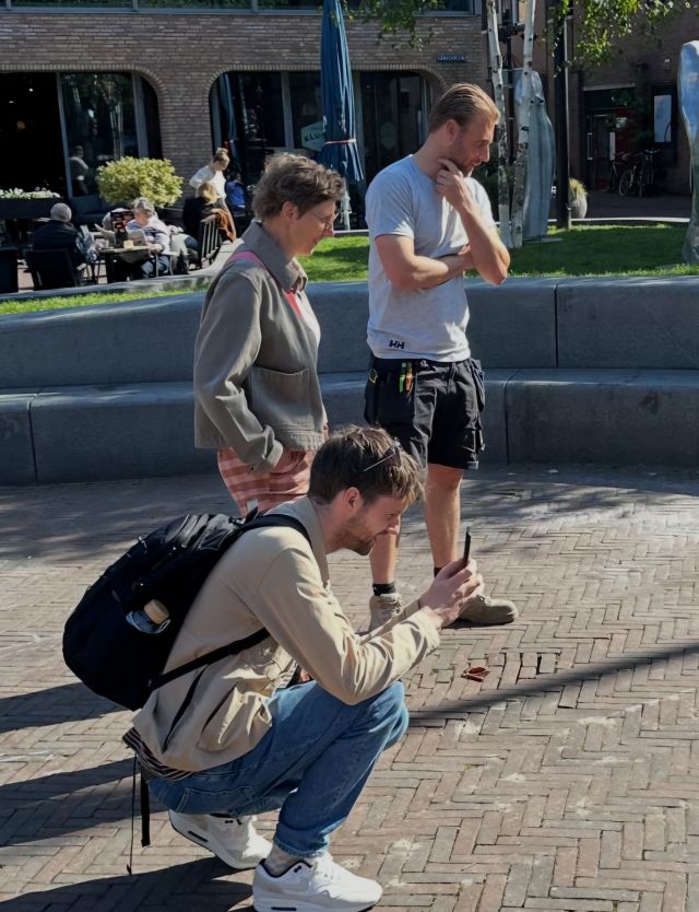 Dion Harder van Swart Natuursteen, samen met Gonna de Reus van de vakgroep Erfgoed en Chiel Schilder van de vakgroep Cultuur. Chiel zit gehurkt en maakt een foto van het werk