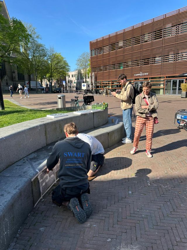 Chiel Schilder van de vakgroep Cultuur en Gonna de Reus van de vakgroep Erfgoed nemen een kijkje terwijl het team van Swart Natuursteen aan het passen is