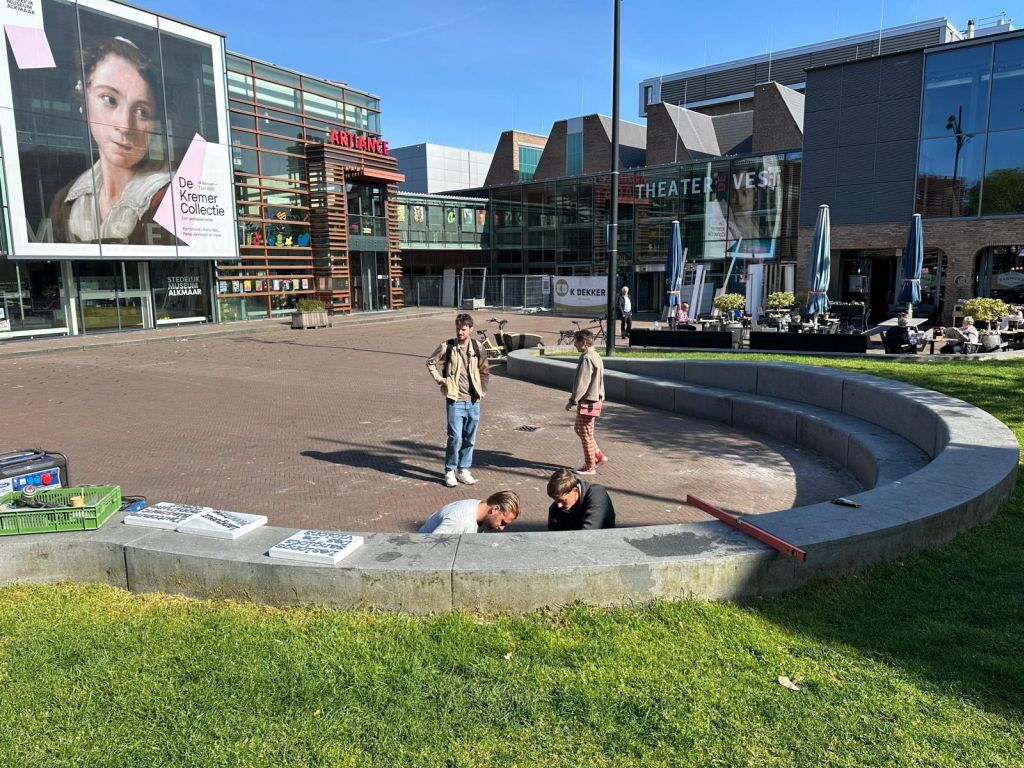 De halfronde stenen bank op het Canadaplein waar in de leuning en de zitting de dichtregels worden aangebracht