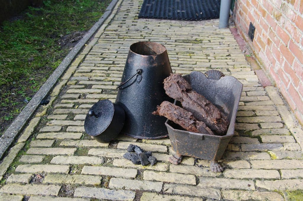 Turf en kolen voor Het Kleinste Huisje. Midden in de kamer stond de oude turf- of kolenkachel. Turf was er genoeg, want Schermerhorn ligt in een oud veengebied.
