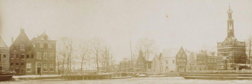 Wintergezicht met de Accijnstoren over het Noordhollandsch kanaal gezien. De toren stond toen nog op zijn oorspronkelijke plek. Circa 1910.