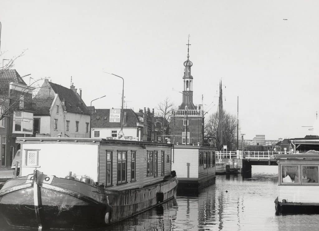 In het midden zicht in de Turfmarkt richting de Accijnstoren. In het water woonschepen. Circa 1980. Foto J. Steijn Fotogroep de Waag.
