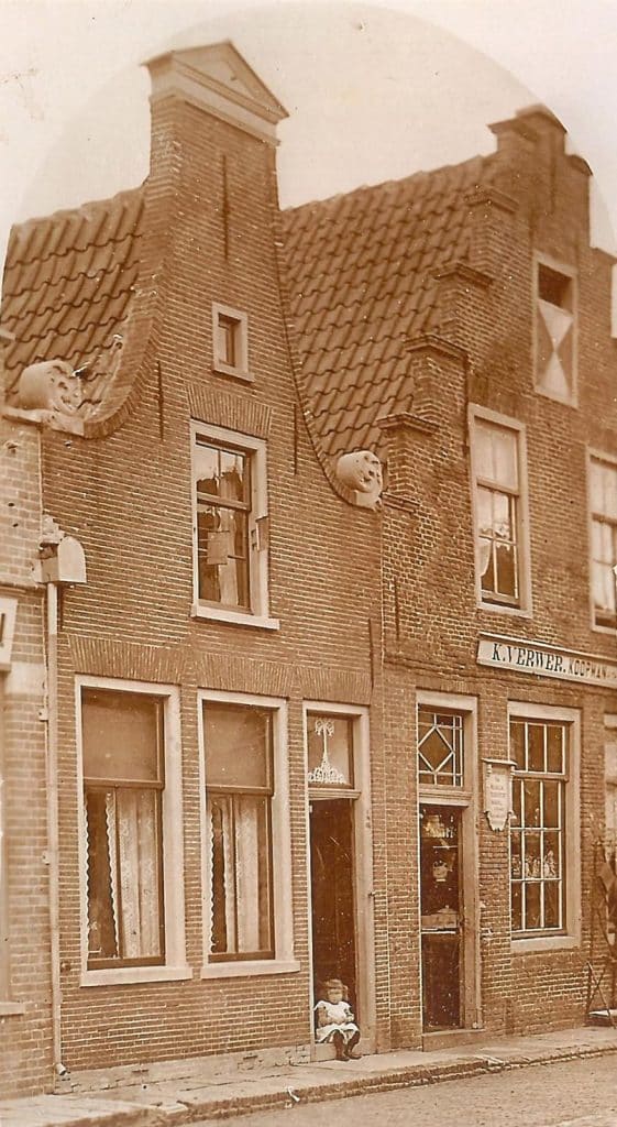 Koningsweg 78 in 1912. In de deuropening zit een klein meisje. De dochter van de familie Lodder die in het pand woont. Rechts de winkel van K. Verwer, uitdragerij.