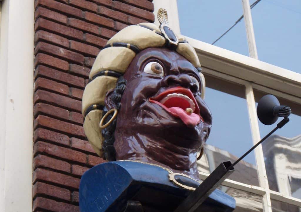 Moriaanshoofd als uithangbord van een drogisterij. Met medicijn op zijn tong. Foto VirtualSteve.