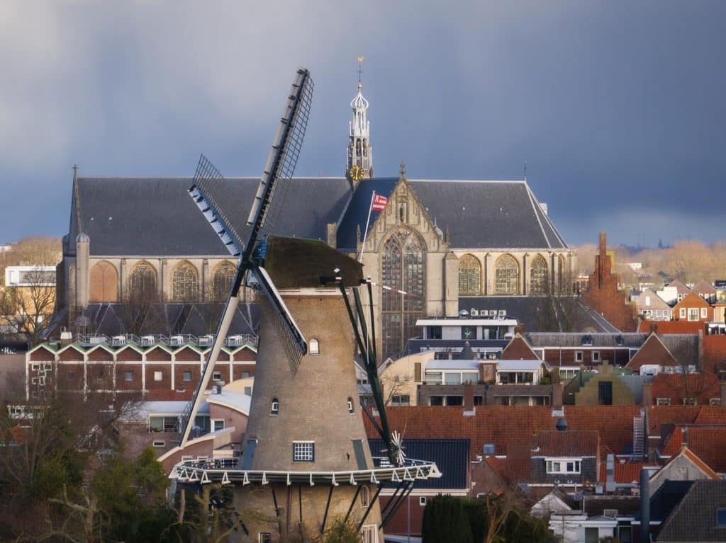 Er hangt een donkere lucht boven de stad. Zicht op de Molen van Piet en het Grote Raam van de Grote Kerk Alkmaar. Foto Erik Boschman 2025.