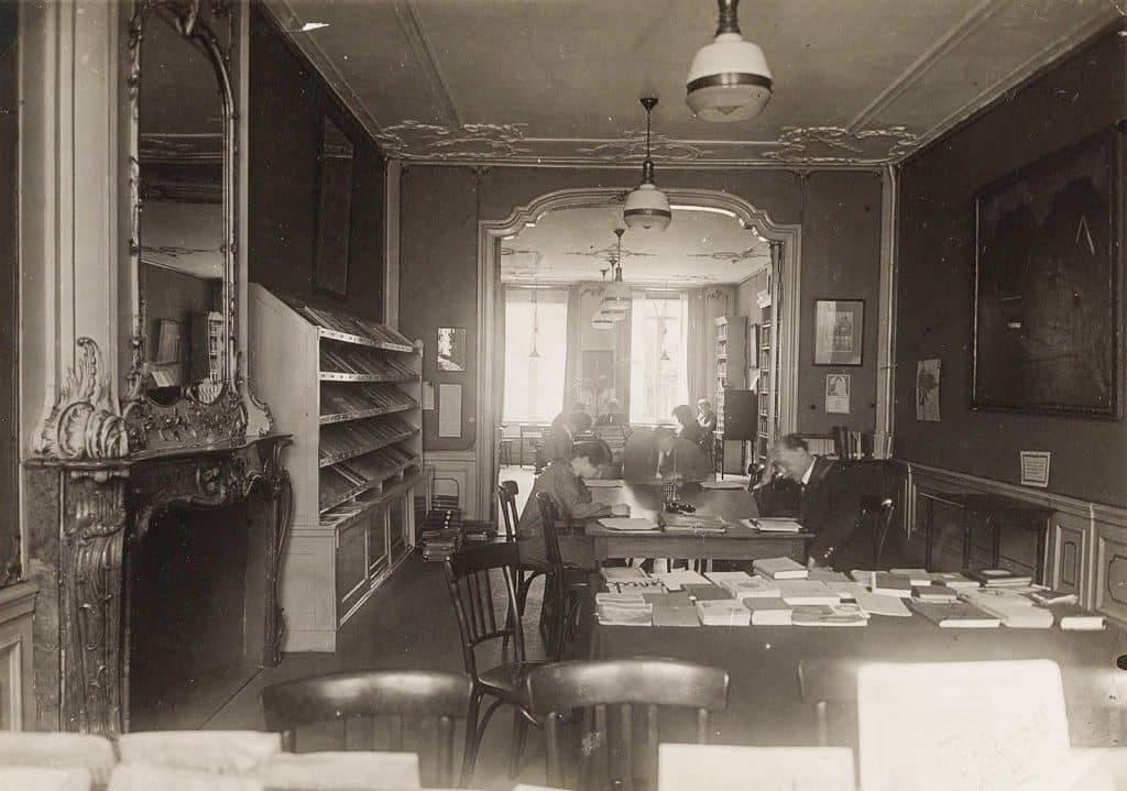 Interieur Openbare Leeszaal in het Moriaanshoofd met een grote port-brisée. Die verbindt twee kamers aan elkaar. Circa 1930. Foto W. Blokker.