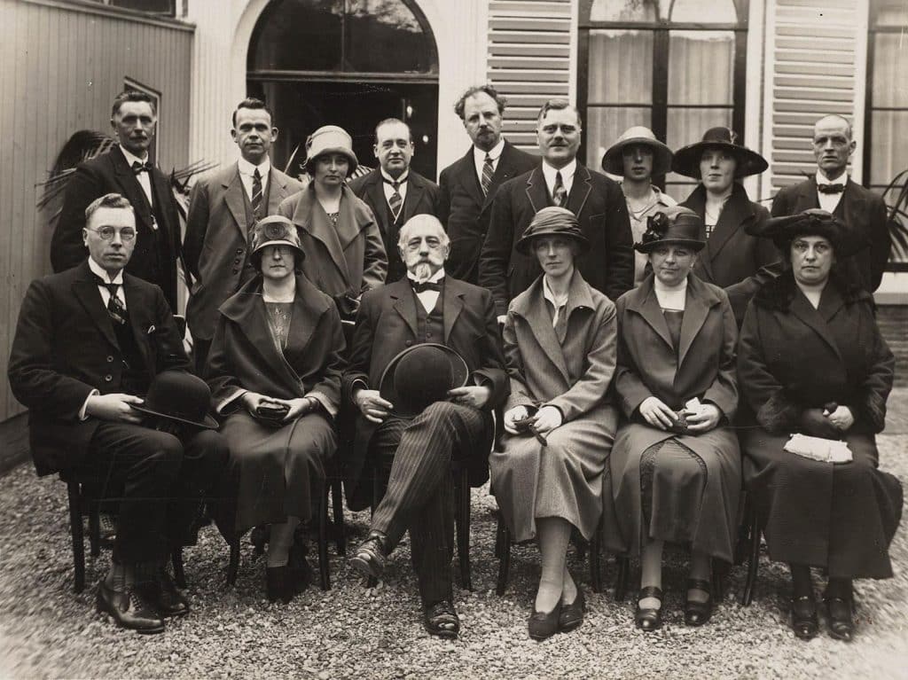 Personeel en bestuur van de Openbare Leeszaal in de tuin achter het Moriaanshoofd. Ter gelegenheid van de ingebruikneming. 28 april 1926, opening van het nieuwe gebouw van de Openbare Leeszaal en bibliotheek, Langestraat 85. Het bestuur en personeel. Zittend: Mr. C.J. de Groot, Mej. M. Kaan, Mr. A.P. H. de Lange, Mej. van Rijn, Mej. Buis en Mevr. Prins-Vlessing. Staande: Van Randwijk, Koopal, Mej. Zaadnoordijk, N.J.M. Dresch, Tj. Adema, G. Grondsma, Mej. Stootjesdijk, Mej. de Waal en Van Enschut. Foto fotobureau Hollandia 1926.