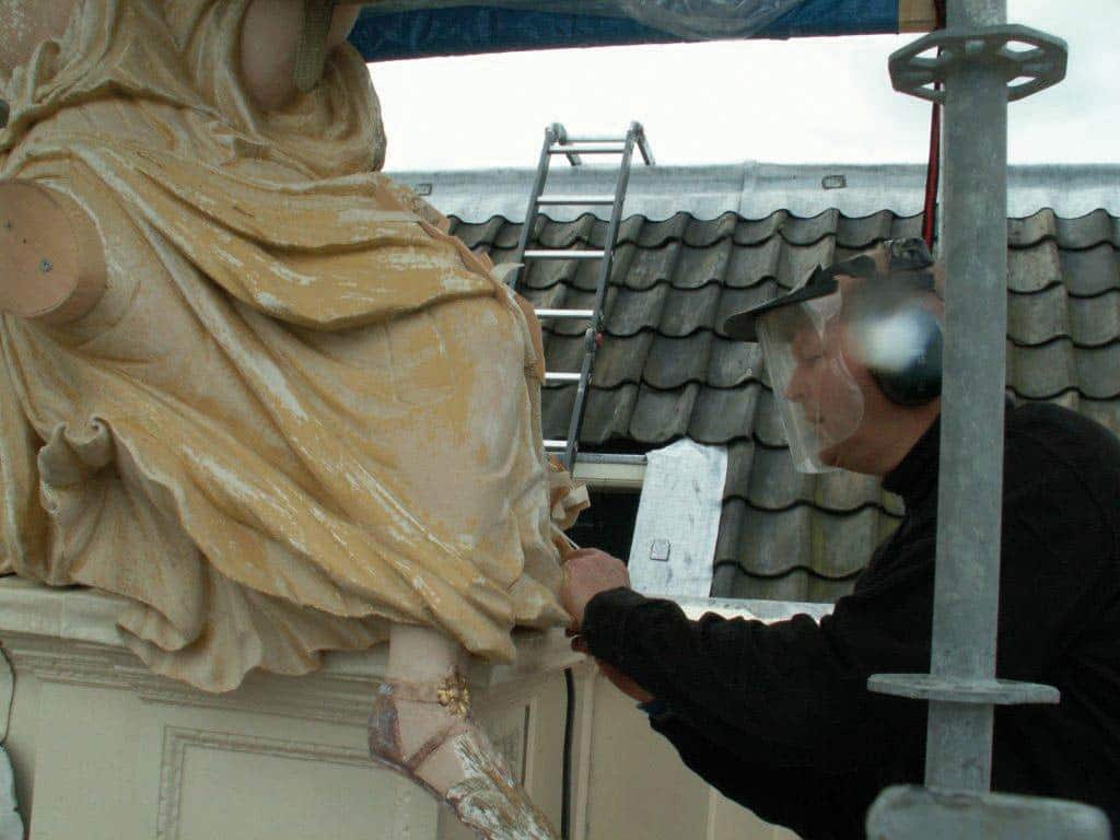 Pieter Koorn aan het werk in 2012. De beeldengroep van het Moriaanshoofd wordt gerestaureerd.