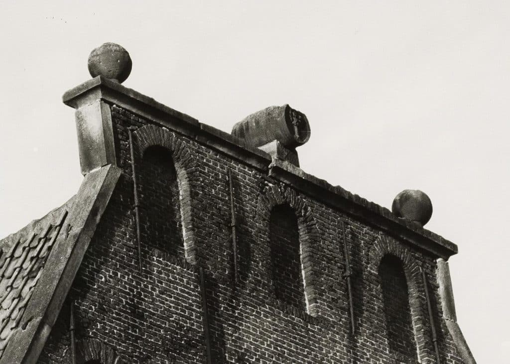 Twee hogels of ornamenten op het dak van de Boom. In het midden een tonnetje met daarop twee bomen gebeiteld. Circa 1985.