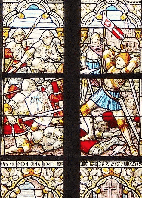 Glas-in-loodraam van het Lam Gods. Soldaat Folkert doodt in de strijd bij Hoorn enkele tegenstanders. Priester Folkert doet als karmeliet boete in het klooster te Haarlem. In de deuropening kijkt zijn medebroeder Jan van Leiden toe.