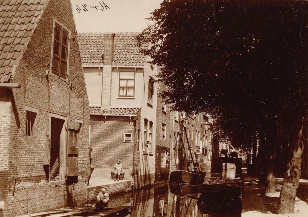 Kooltuin met zicht op de achterzijde van de bebouwing aan de Achterdam. Circa 1910.