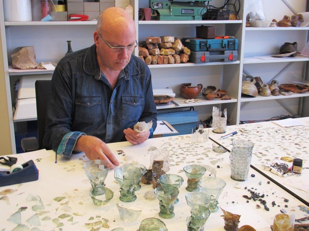 Rob Roedema is glas scherven bij elkaar aan het puzzelen. Circa 2015.
