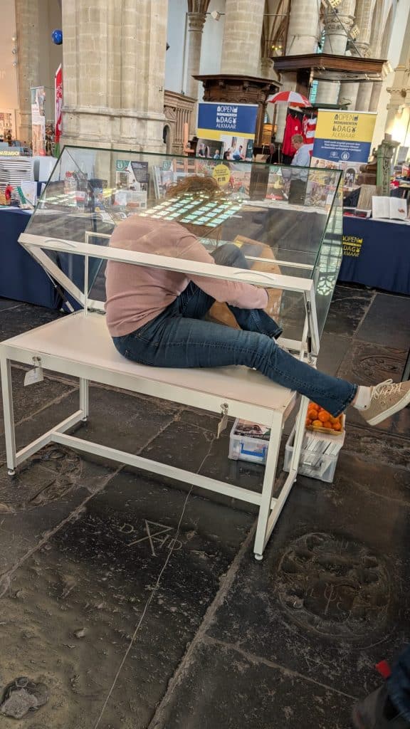 Archeoloog Nancy de Jong in de vitrine van het tinnen bord