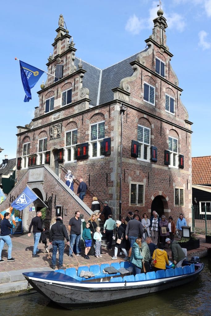 Bezoekers stappen uit de boot naast Raadhuis De Rijp