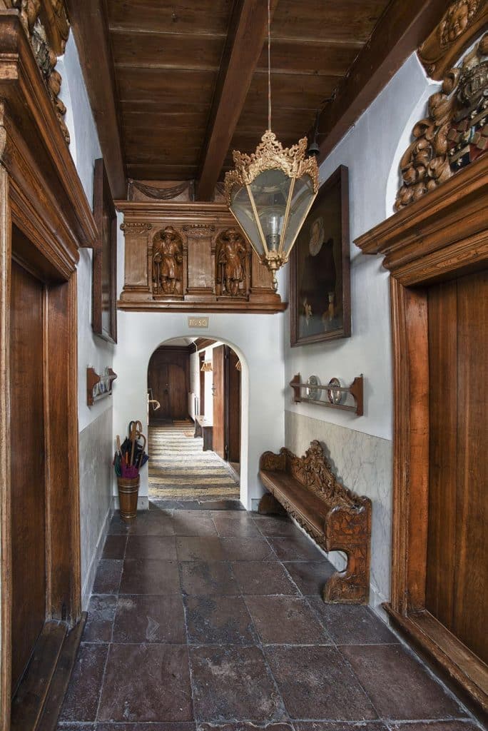 Entree en gang van provenhuis van Nordingen of het Huis van Achten. Je ziet boven de poort wee houtsneden van een provenier. De hond staat voor dienstbaarheid en trouw, zoals een echte provenier betaamt. De beeldjes zijn uit 1658 en waren best duur voor die tijd: 81 gulden! Foto J. Elsinga 2012.