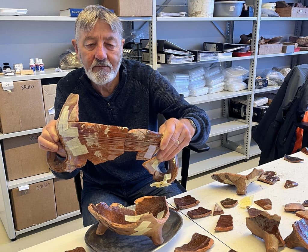 Sjaak aan het puzzelen met pottenbakkersafval van de opgraving achter Verdronkenoord 68.