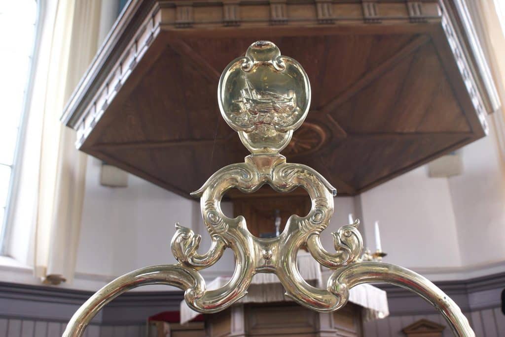 Koperen doopboog met cartouche-vormig schild waarop een haringbuis is afgebeeld in de Dorpskerk in West-Graftdijk. Foto J. van Zanten 2009.