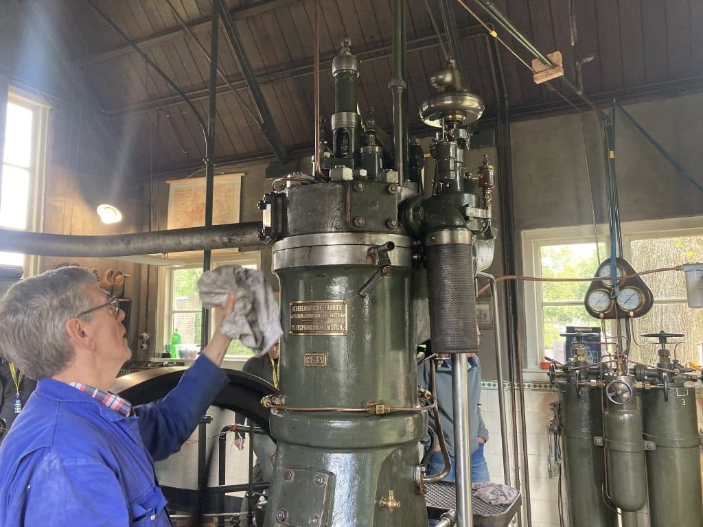 Het interieur van het Dieselgemaal aan de Cort van der Lindenkade. Met een medewerker bij de dieselmotor.