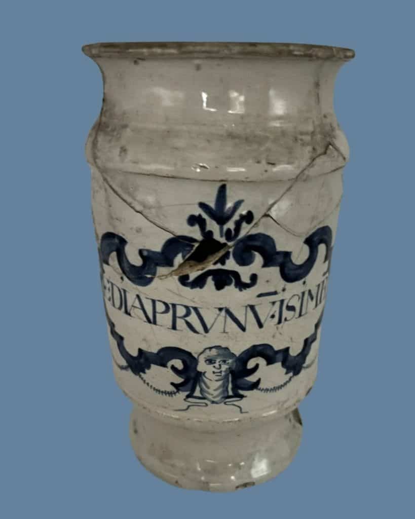 Delfts blauwe apothekerspot met tekst DIAPRUNU en gezichtje onder de tekst