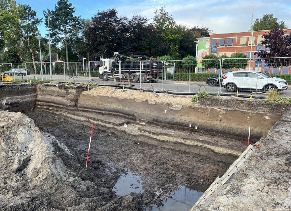 Beeld van de verschillende lagen die zichtbaar werden. Met in het midden, waar de lagen worden onderbroken, de greppel die verder is onderzocht.