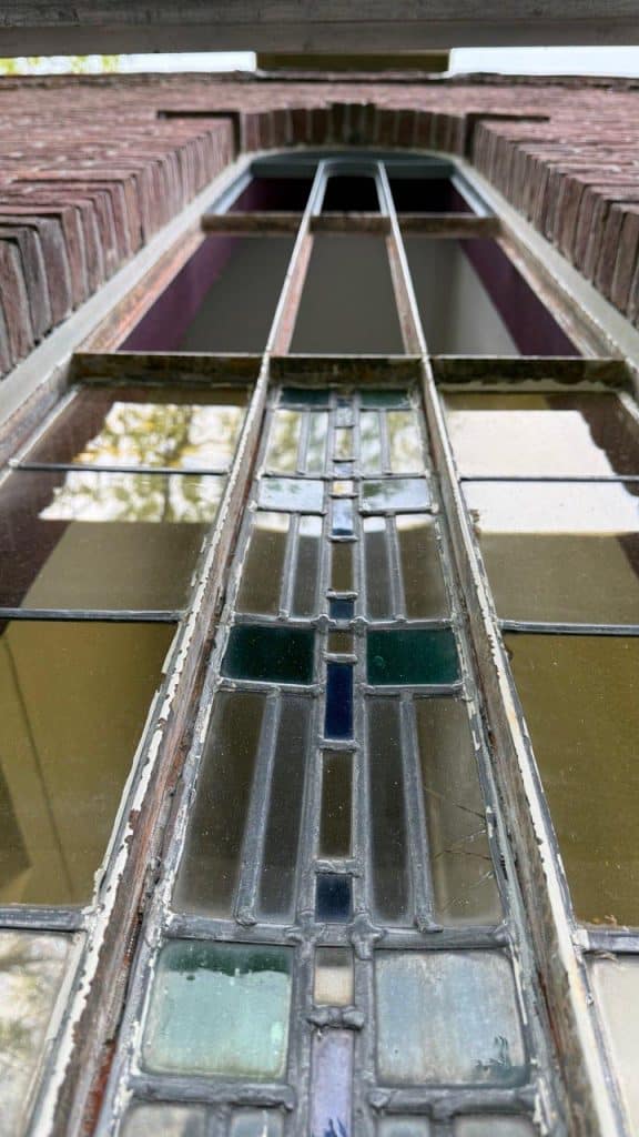 Close up van het te isoleren glas-in-loodraam van de onderwijzerswoning.