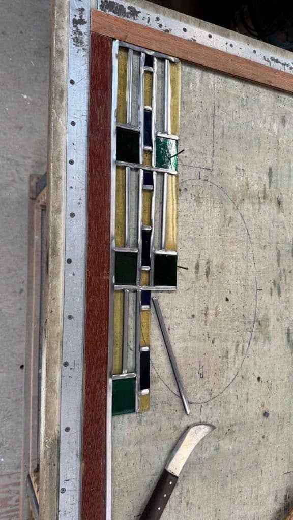 Herstelwerk aan het glas-in-lood in de werkplaats van Sjoerd.