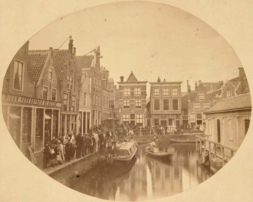 Gezicht op de Kraanbuurt vanaf de Platte Stenenbrug in 1865. Rechts zie je de achterzijde van de visbanken met toegang tot de gracht.