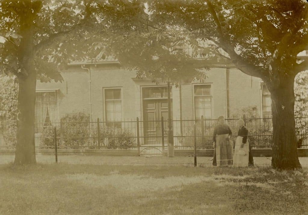 Achterzijde van het Wildemanshof aan de Wildemanstraat. Rechts staan 2 vrouwen. Circa 1915.