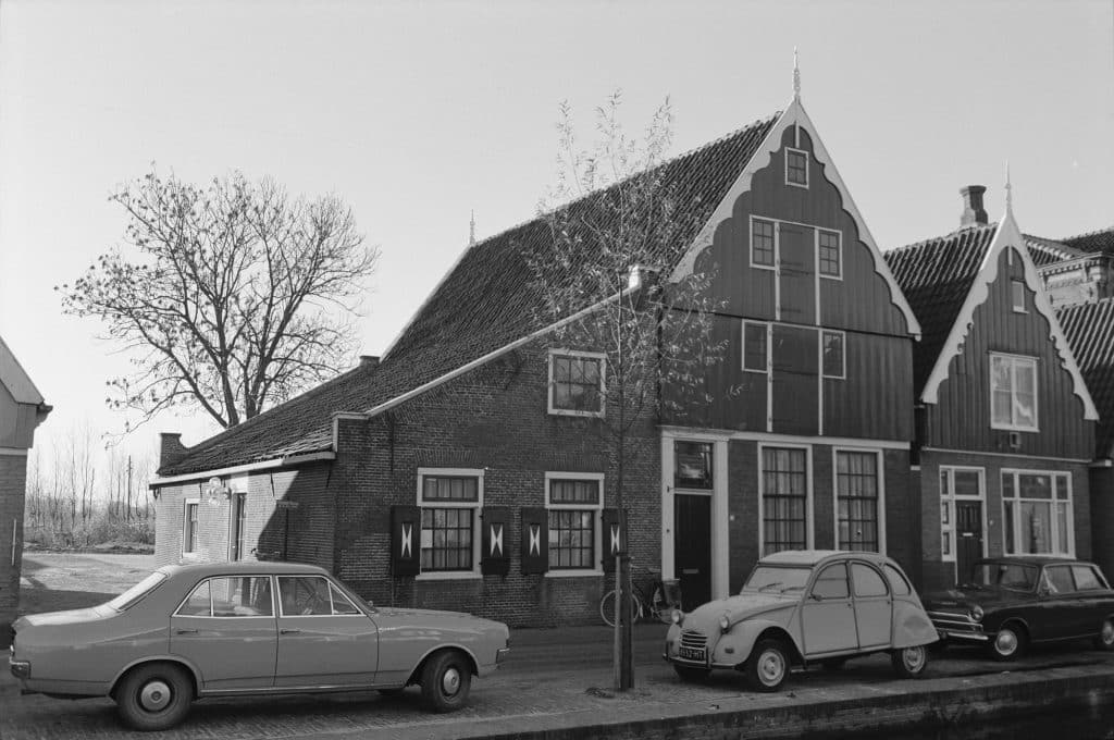 De Rijp begin jaren 1970 Links Tuingracht 13 het voormalige Gemeene Wees- en Armenhuis. Op dat moment is dat het Kruisgebouw voor zuigelingenzorg. Rechts Tuingracht 14, het huis van de familie Oldenburg. Opvallende windveren en makelaars. Twee melkmeisjes boven elkaar. Een fiets, drie personenauto’s (de middelste een Citroën 2CV, de linker waarschijnlijk een Opel). Beeldcollectie Oudheidkundige Vereniging Het Schermereiland