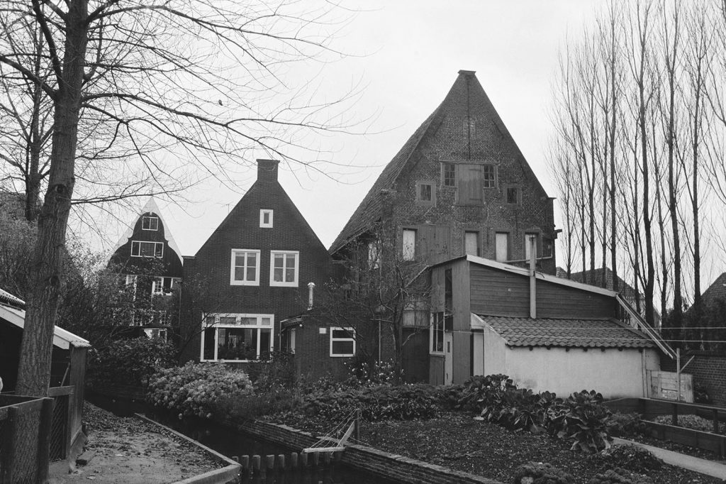 Links eerst het pand van Museum In t Houten Huis. Het slootje dat onderaan schuin door het beeld loopt, verbindt de Tuingracht via het Bakkersgrachtje met het Jan Boonplein.