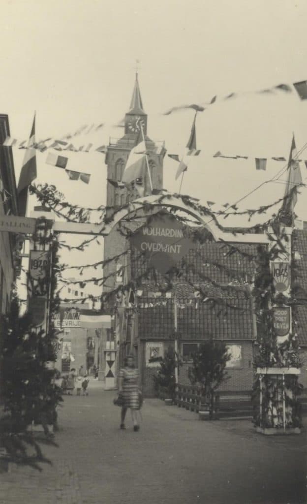 Prentbriefkaart Collectie Kaptein Bevrijdingsfeesten in De Rijp na de Tweede Wereldoorlog. Op deze kaart is de versiering op het Jan Boonplein (toen nog Middelstraat) te zien. Met teksten als Volharding Overwint, 1940-1945, Bevrijd… , Hoop Doet Leven. Het wijkje met het huisje erachter zijn er nog, zo te zien intact.