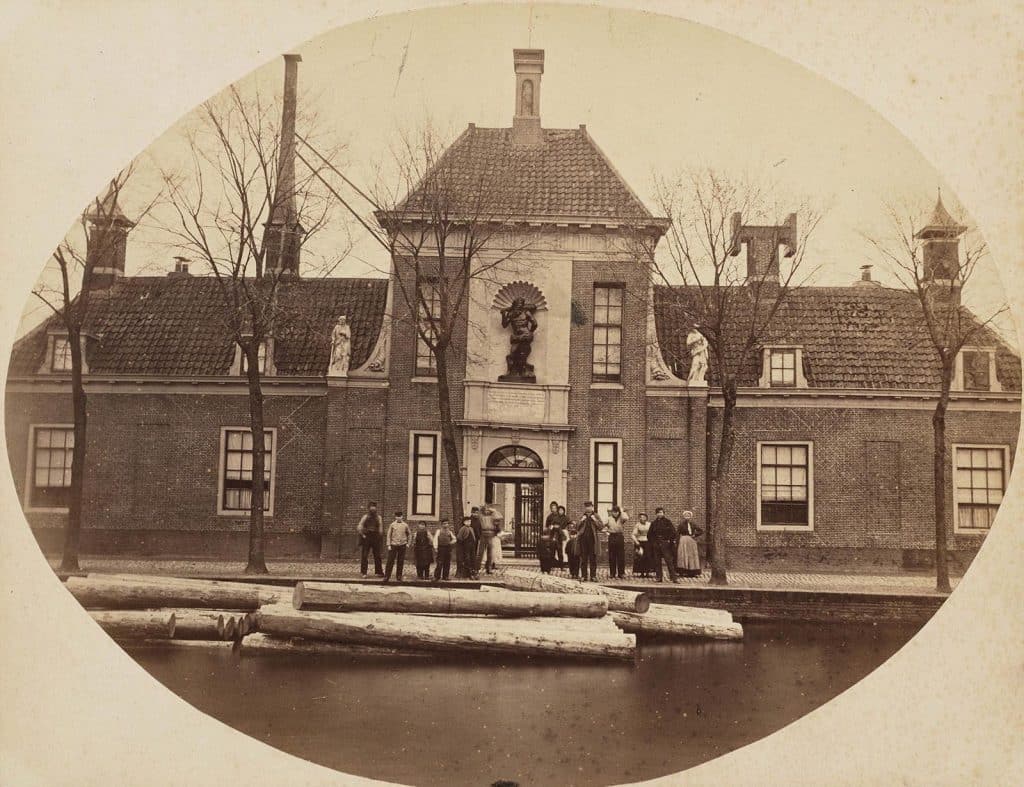 Voorgevel van het Wildemanshofje met beeldengroep en de schoorstenen in oorspronkelijke staat. Circa 1870.