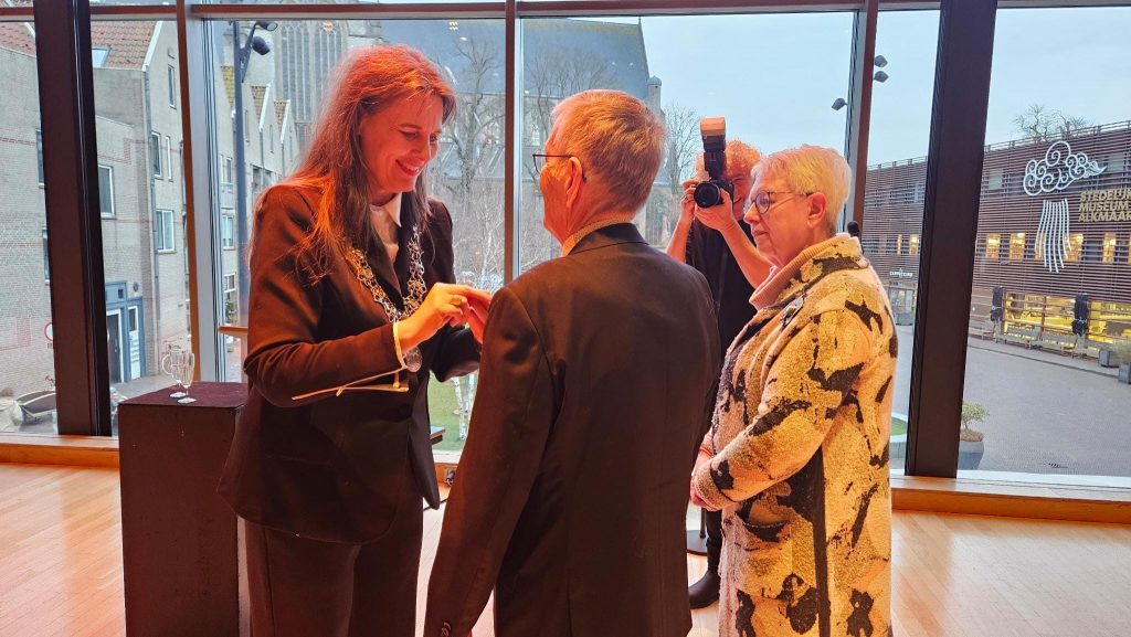 Burgemeester Anja Schouten overhandigt het gouden ere-insigne aan Piet Verhoeven.